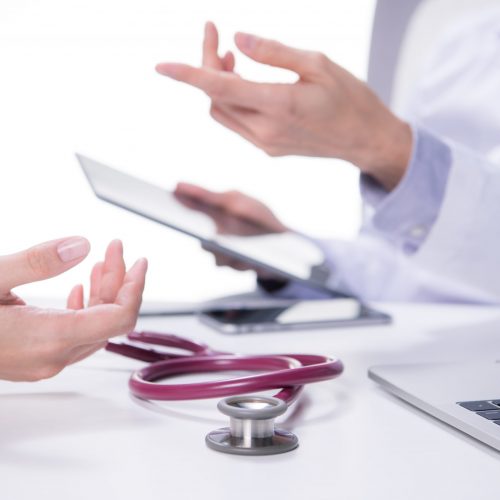 Medical doctor and patient discussing and consulting in hospital examination room
